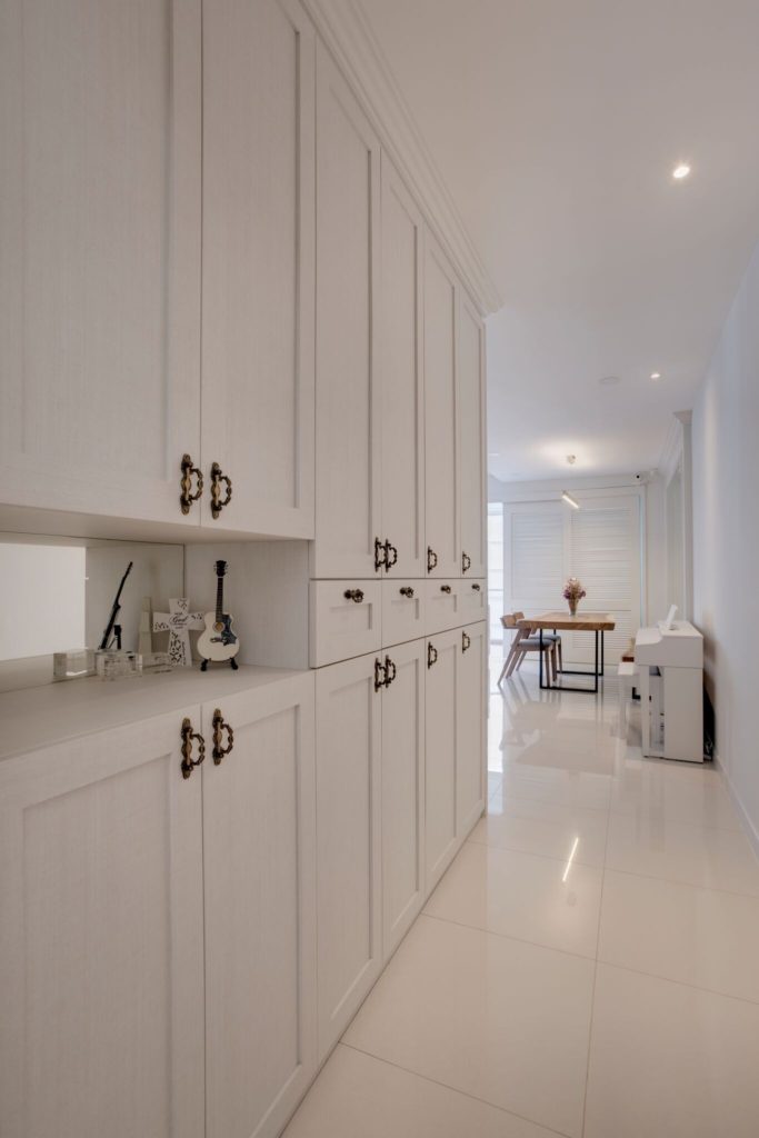 Off-white passageway with white cupboards and shelves