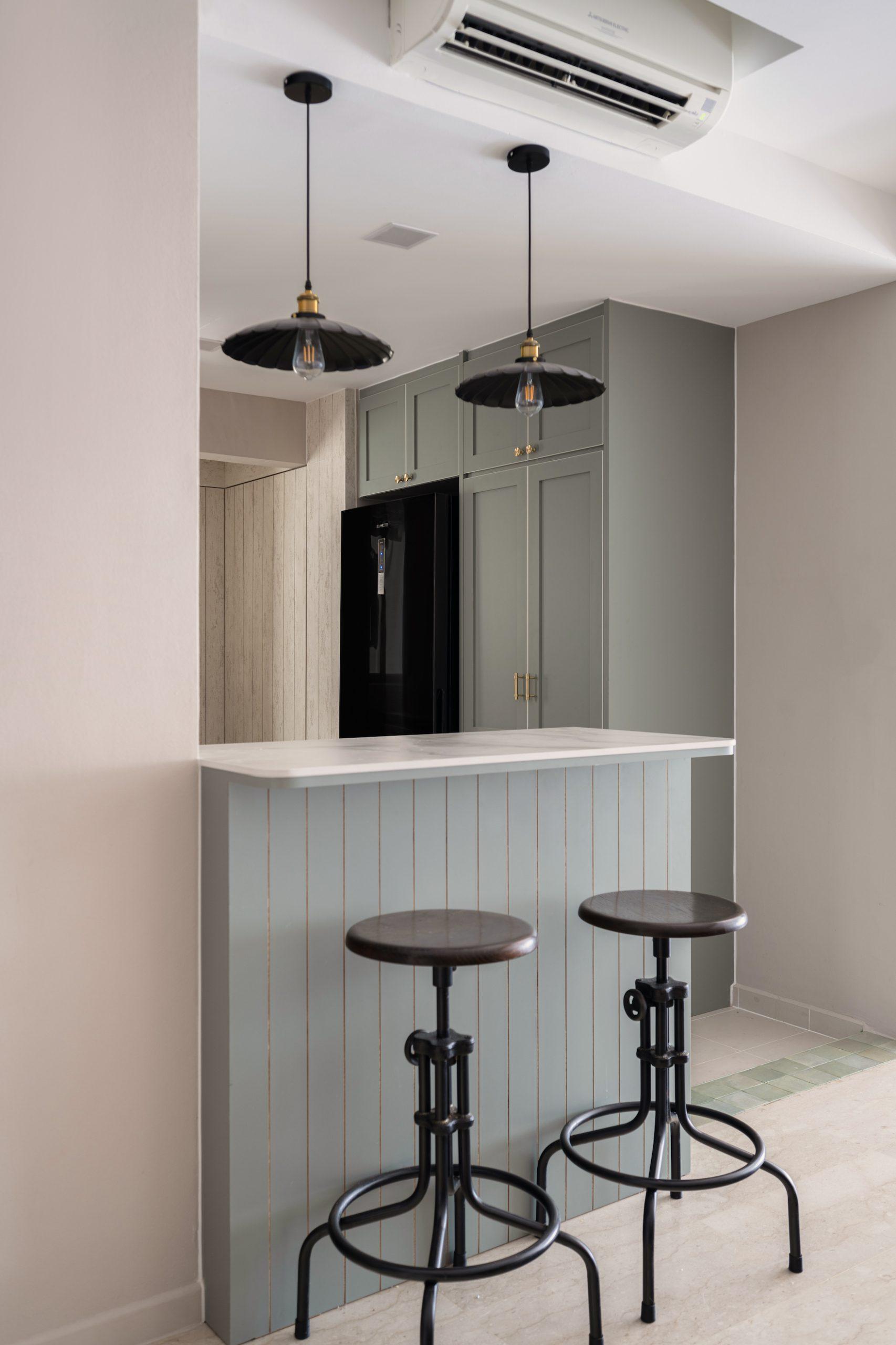 Kitchen island with hanging Edison lamps and metallic stools